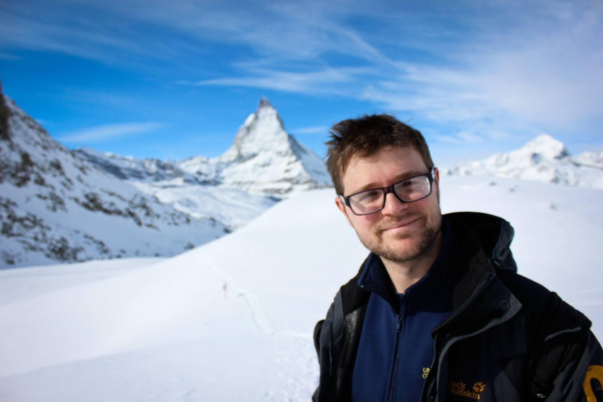 White male posed in front of a snowy mountain