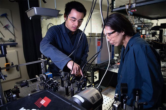 two researchers working on a device